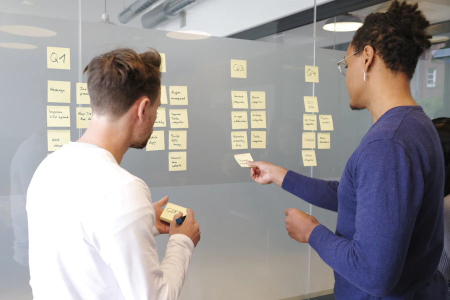 Two professionals organizing a workflow with sticky notes